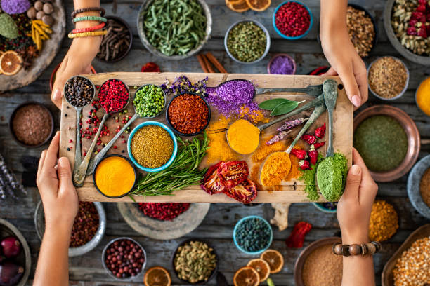 many various multi colored spices and dried fruits at the hands of two women. - ingredient fennel food dry imagens e fotografias de stock