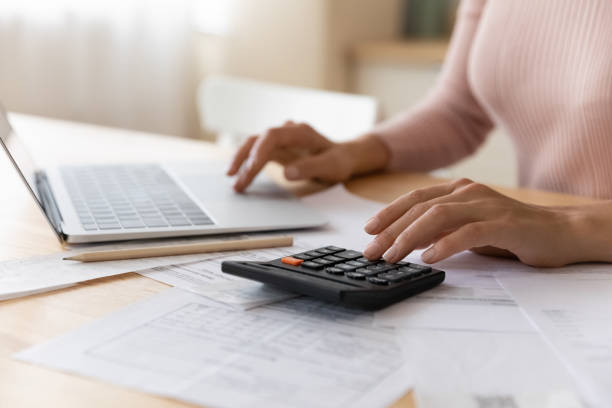 istock Close up cropped woman planning budget, using laptop and calculator 1432616238