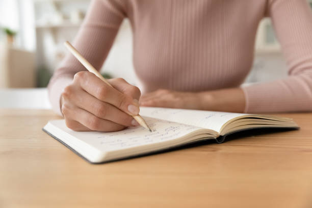 istock Close up cropped of woman taking notes in notebook 1432616242