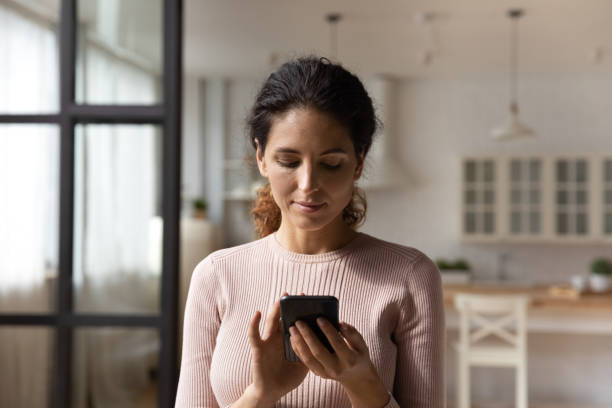 istock Head shot focused woman looking at smartphone screen, browsing apps 1432616250