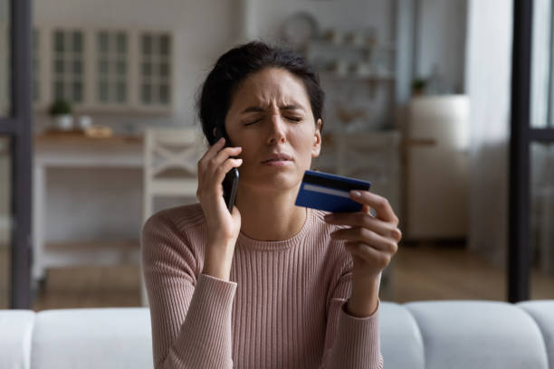 istock Unhappy woman talking on phone, having problem with credit card 1432616279