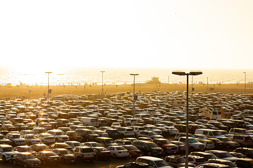The parking lot at Santa Monica Beach on a holiday weekend, crowded with cars, trucks, and vans in the late afternoon.