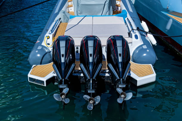 Three powerful outboard motors Three outboard powerful boat engines on the transom of a boat in the harbor motorboat maintenance stock pictures, royalty-free photos & images