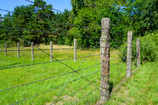 barbed wire fence with concrete posts around the restricted area of a military object