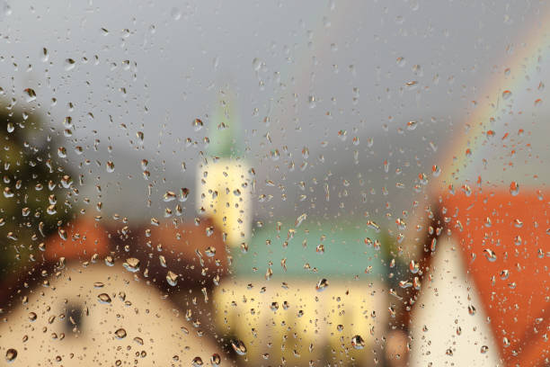 Rain drops on window glass with beautiful rainbow stock photo