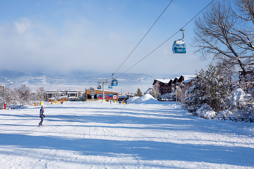 Bansko, Bulgaria - February 3, 2022: Bulgarian winter ski resort with ski slope, lift cabins and gondola station