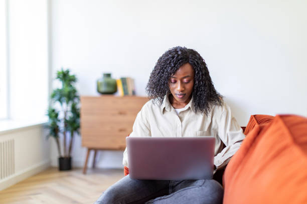 istock Young Black woman working with laptop from home 1432621903