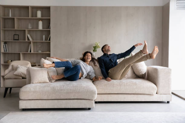 istock Spouses of new homeowners falling on big soft couch 1432628707