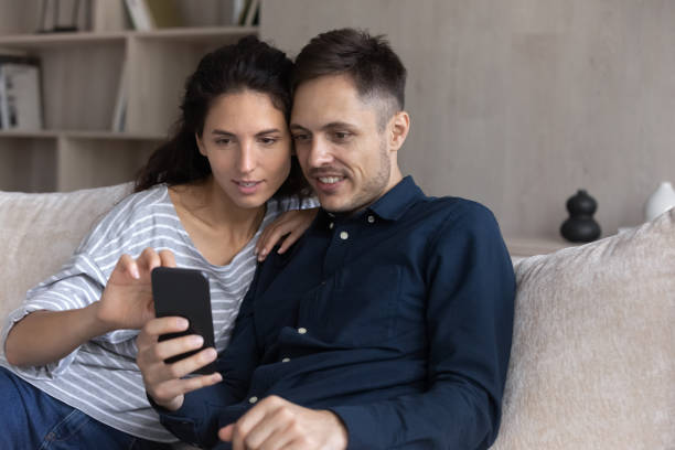 istock Focused millennial couple using online service on smartphone together 1432628727