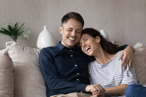 istock Cheerful millennial couple relaxing and laughing on couch 1432628742