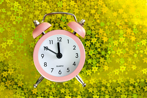 Alarm clock on green grass