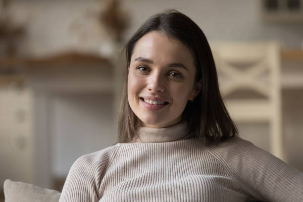 istock Happy tenant girl resting on home sofa, looking at camera 1432634211