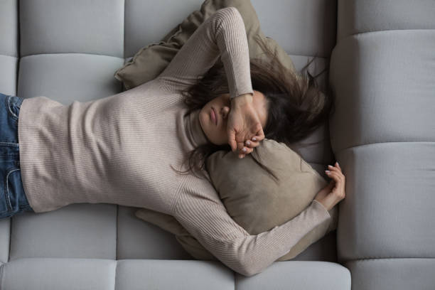 Peaceful girl lying on back on comfortable couch at home stock photo