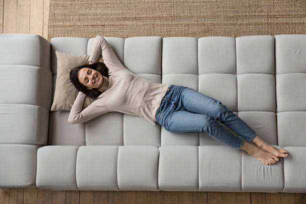 istock Relaxed cheerful 20s girl resting on soft comfortable big sofa 1432634236