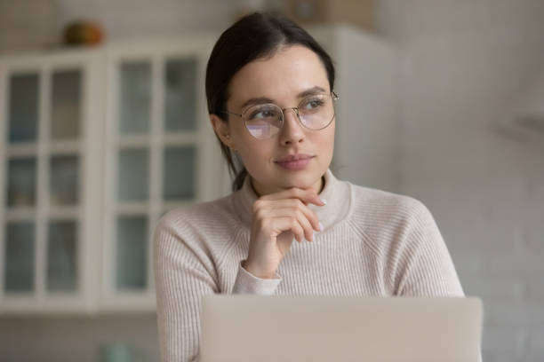 istock Thoughtful laptop user in stylish eyeglasses sitting at home workplace 1432634291