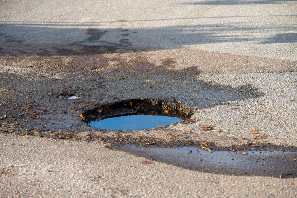 istock A dep pothole in asphalt parking lot filled with water. 1432635472