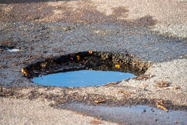 istock A dep pothole in asphalt parking lot filled with water. 1432635484