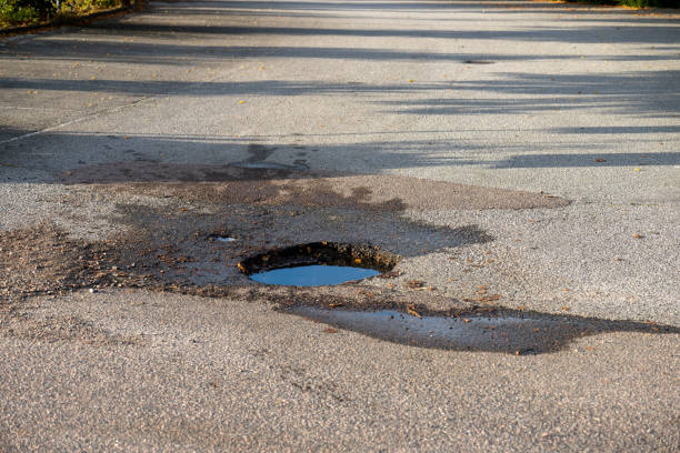 istock A dep pothole in asphalt parking lot filled with water. 1432635494