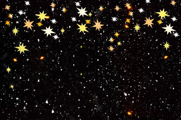 Christmas night background with falling snow and gold abstract stars. Lots of space for text