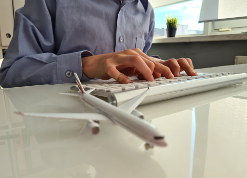 Person books plane ticket on Internet. Buying and booking flight tickets
