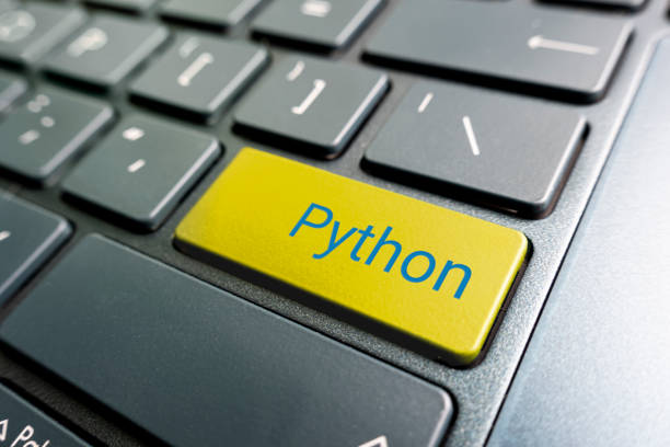 現代のラップトップの黄色のキーボードのpythonのボタン。 - python ストックフォトと画像