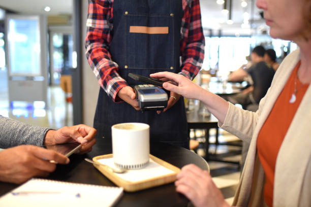 istock couple paying with mobile phone to waitress in cafeteria 1432637991