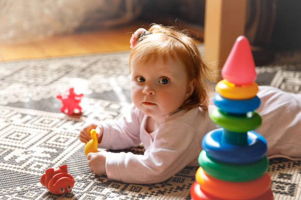 床の上の赤い髪の赤ちゃん - 1歳以上2歳未満 ストックフォトと画像