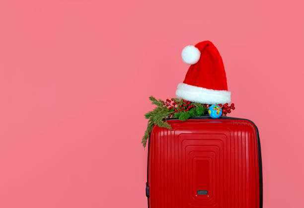 istock A red suitcase is a small decorative Christmas branch, a red Santa Claus hat 1432642387