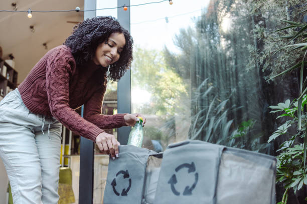 istock Young woman puts plastic waste into recycling bags 1432643914