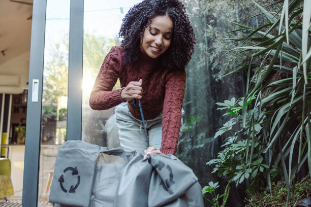 istock Young woman puts waste into recycling bags 1432644099
