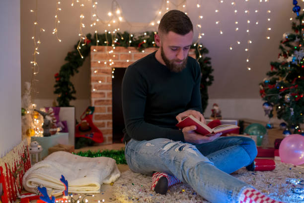 istock young man with a beard sitting at home near the Christmas tree 1432645505