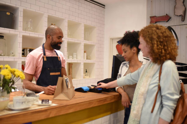 istock friends paying in a store with mobile phone 1432648769