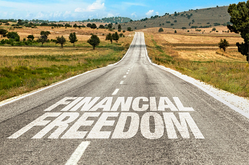 Financial freedom text written on road