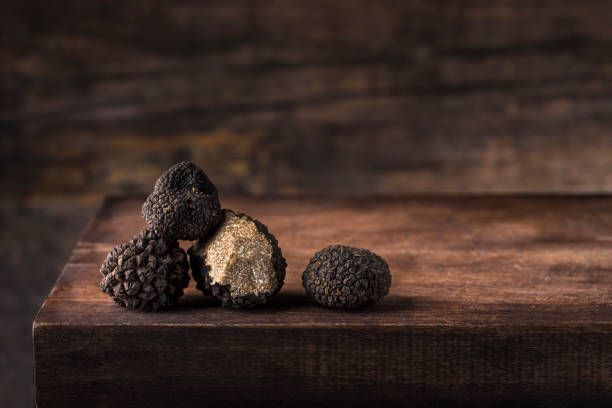 Black truffles in antique  wooden board, rustic style, low key, selective focus, macro, copy space for text. Season of black truffle. Autumn gourmet cuisine of Piedmont, Northern Italy, Spain and France Black truffles in antique  wooden board, rustic style, low key, selective focus, macro, copy space for text. Season of black truffle. Autumn gourmet cuisine of Piedmont, Northern Italy, Spain and France scene scented stock pictures, royalty-free photos & images