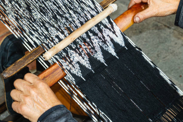 istock Man is making scarf in technique IKAT 1432652667