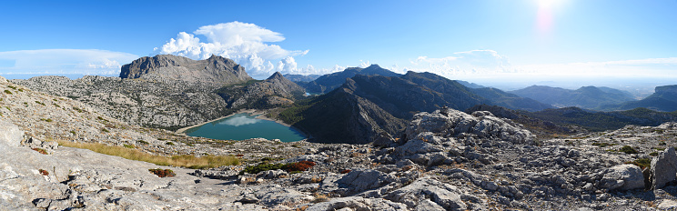 Panoramic view of Puig Major and Embassament de Cúber in Mallorca, Spain. The reservoir is in the Serra de Tramuntana mountain range in front of the island's highest peak, with dramatic clouds looming.