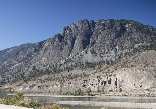 Arthur Seat Mountain, also known as Art's Ass, stands in the Clear Range of the Interior Plateau. Foreground shows the Thompson River viewed from the Trans-Canada Highway at Spences Bridge. Autumn midday in the Thompson-Nicola Regional District.