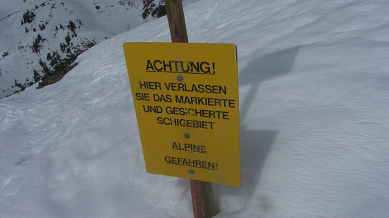 a danger of avalanches warning sign on a snowy ski area