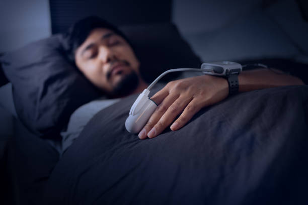 homem usando um oxímetro de pulso - teste de estudo de sono em casa para apneia do sono - pulse oxymeter - fotografias e filmes do acervo