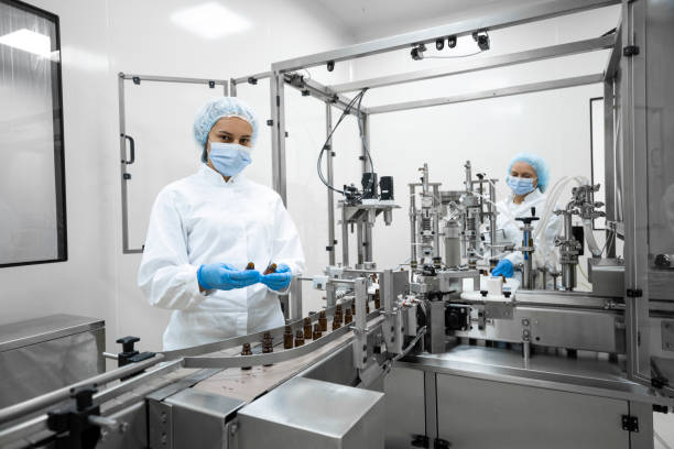 Two fully equipped coworkers in protective workwear seen in a pharmaceutical laboratory stock photo