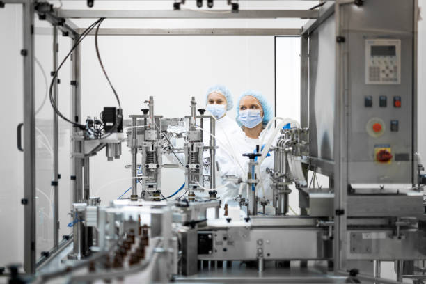 istock Fully equipped technicians in protective workwear seen in a pharmaceutical laboratory 1432665196
