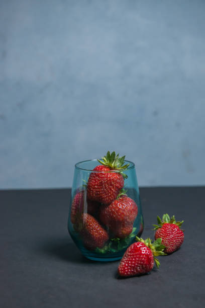 istock Fresh strawberries in a beautiful glass on a dark blue background. tonic. selective focus. atmospheric summer background, mood. advertising summer parties. promotional summer offers. 1432666662