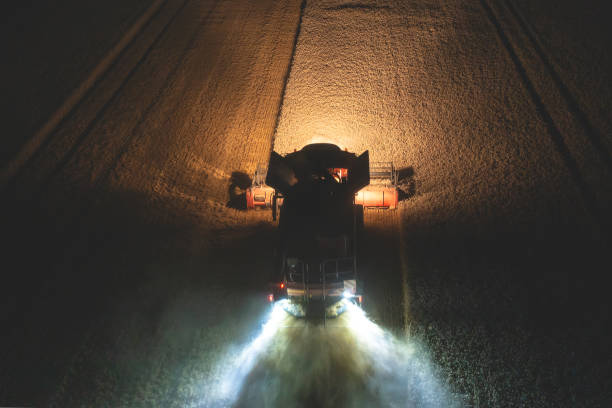 夜間に小麦を収穫するハーベスターの航空写真 - tractor farm uk agriculture ストックフォトと画像