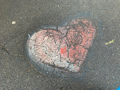 Pink heart drawing on the asphalt