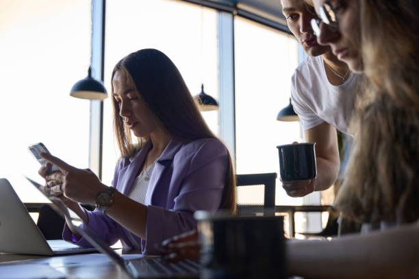 istock Man and two women are busy working in gadgets at a common table 1432674886