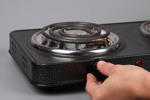 hand turns on the electric stove, temperature control