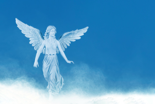 Angel on white cloud against blue clear sky with copy space