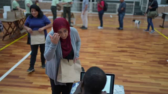 Volunteer talking to islamic woman during control in a sheltering