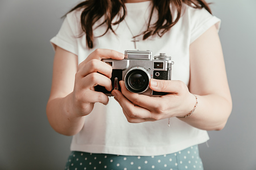 Girl holding an old vintage camera in her hand