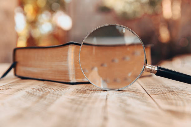 istock Book and magnifier on wooden table 1432689335